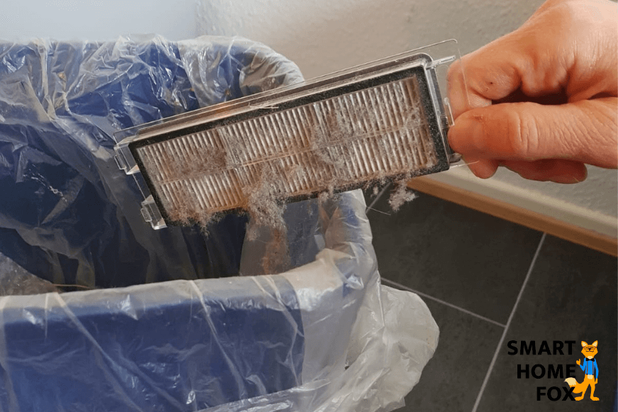 HEPA-фильтр выбивается над мусорным ведром.